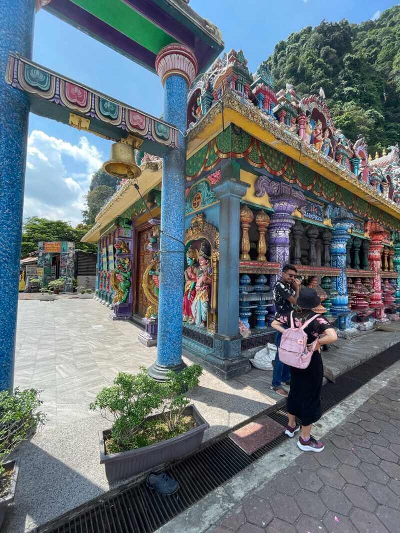 two people standing near Batu Cave temple in Malaysia