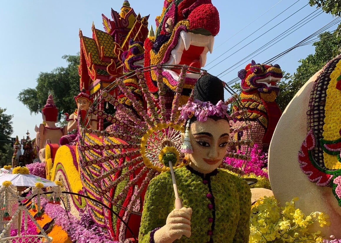 Thai woman and dragon on a parade float made and decorated in colourful flowers