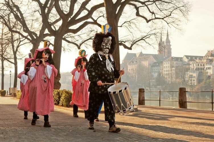 People wearing costumes and playing instruments in Basel Fasnacht Switzeland