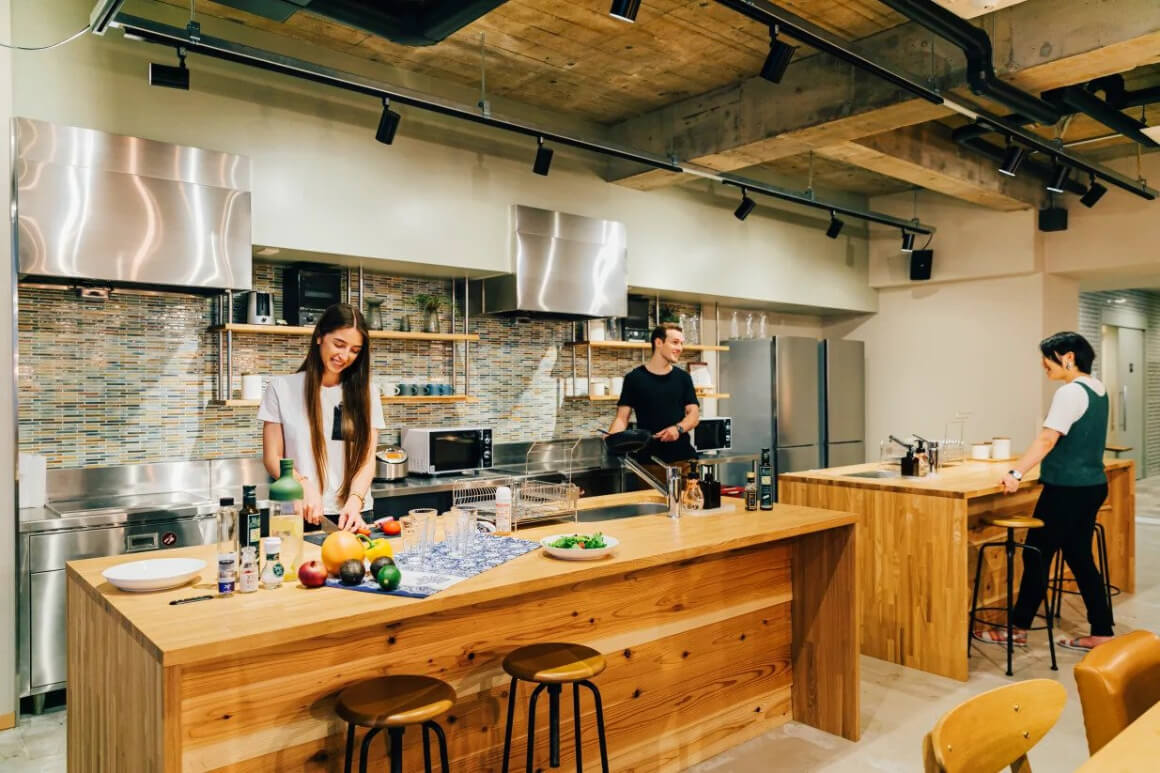 Three guests in the kitchen of The Stay Osaka hostel