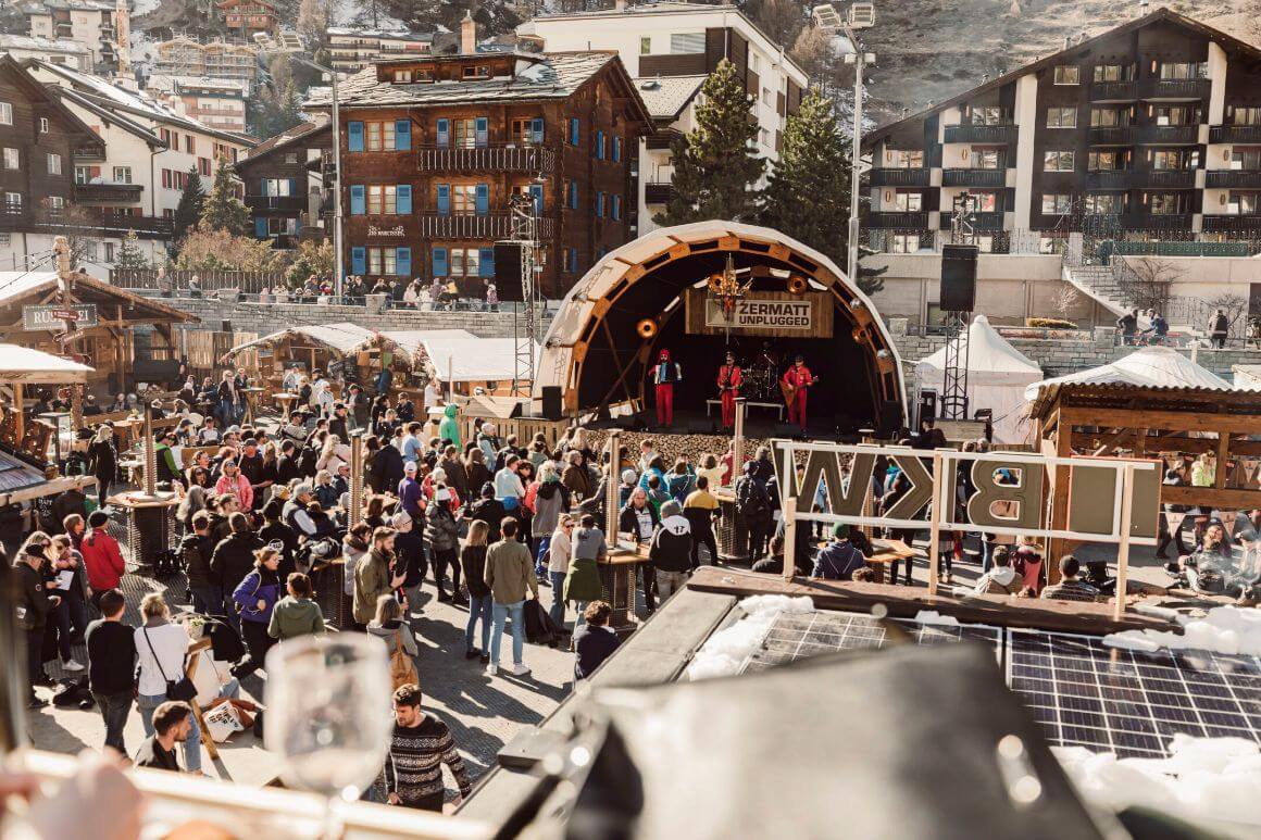 People gathered in front of a stage with musicians performing in Zermatt Unplugged, Switzerland