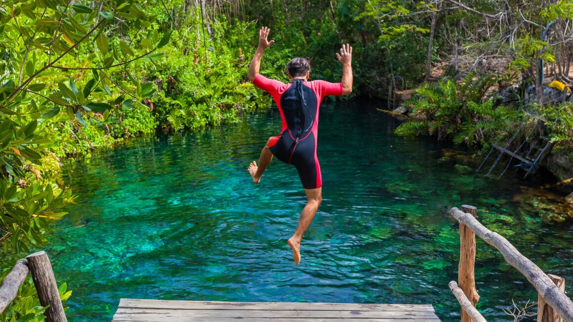 man jumping into a cenote.