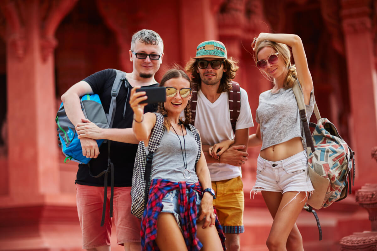 group of digital nomads in thailand at a red colored buddhist temple