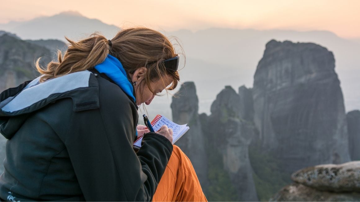 girl journaling in mountains