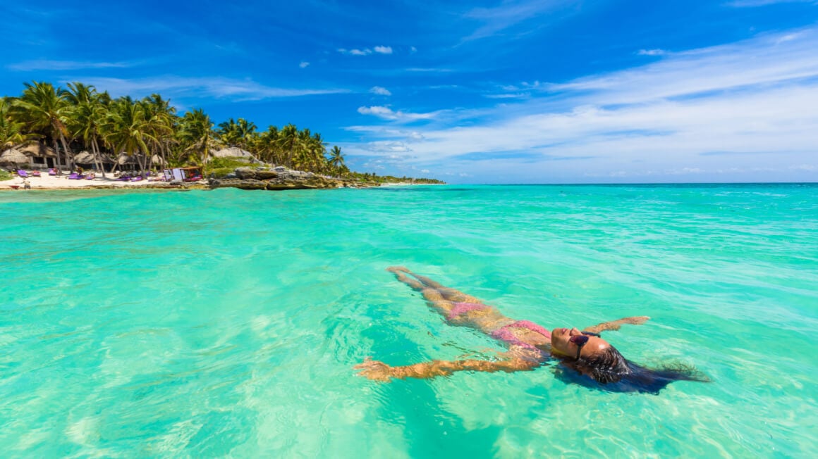 solo female traveler chilling in the sea on Cancun beach in Cancun Mexico