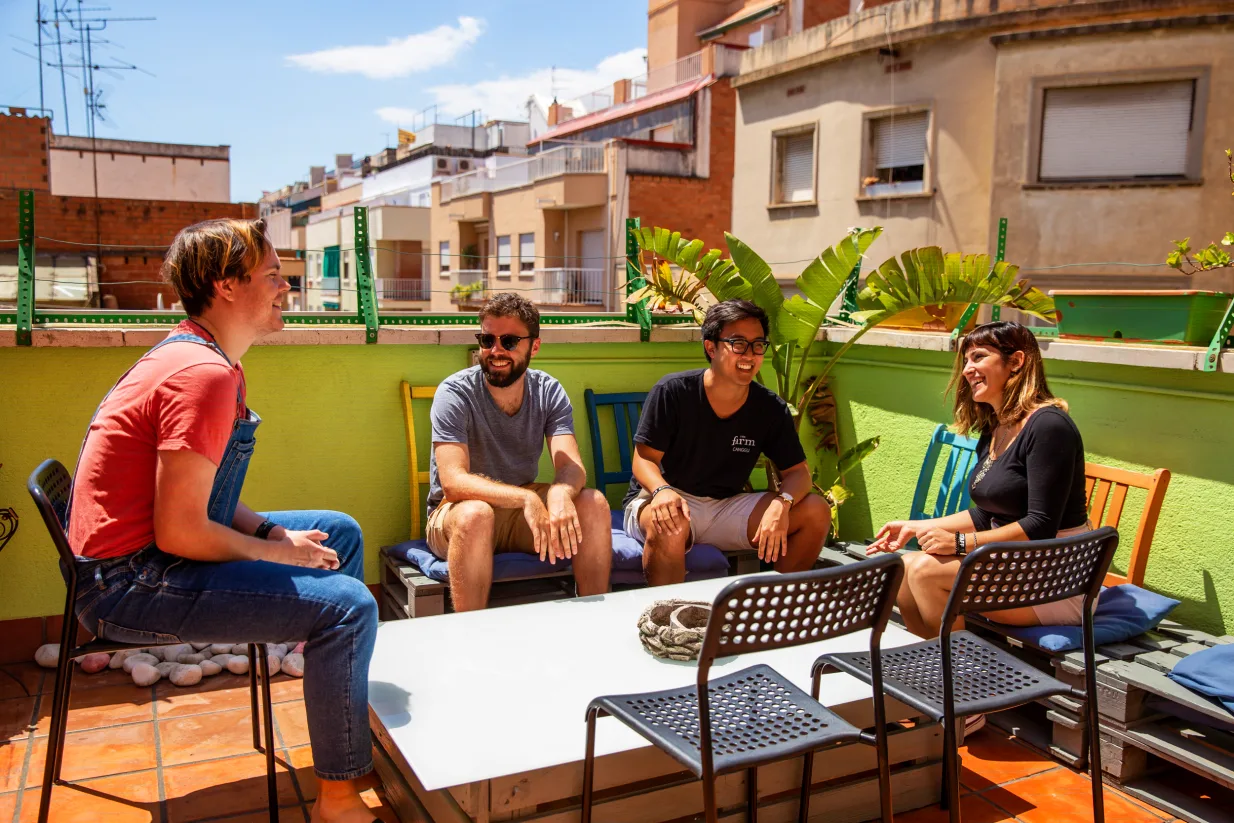 Hostel One Sants balcony area with guests socialising.