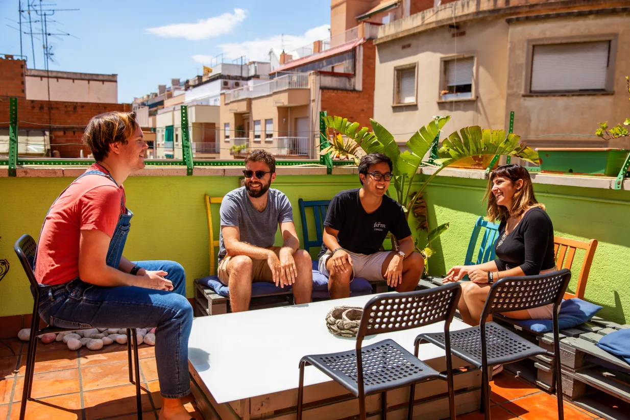 Hostel One Sants balcony area with guests socialising on a rooftop terrace.