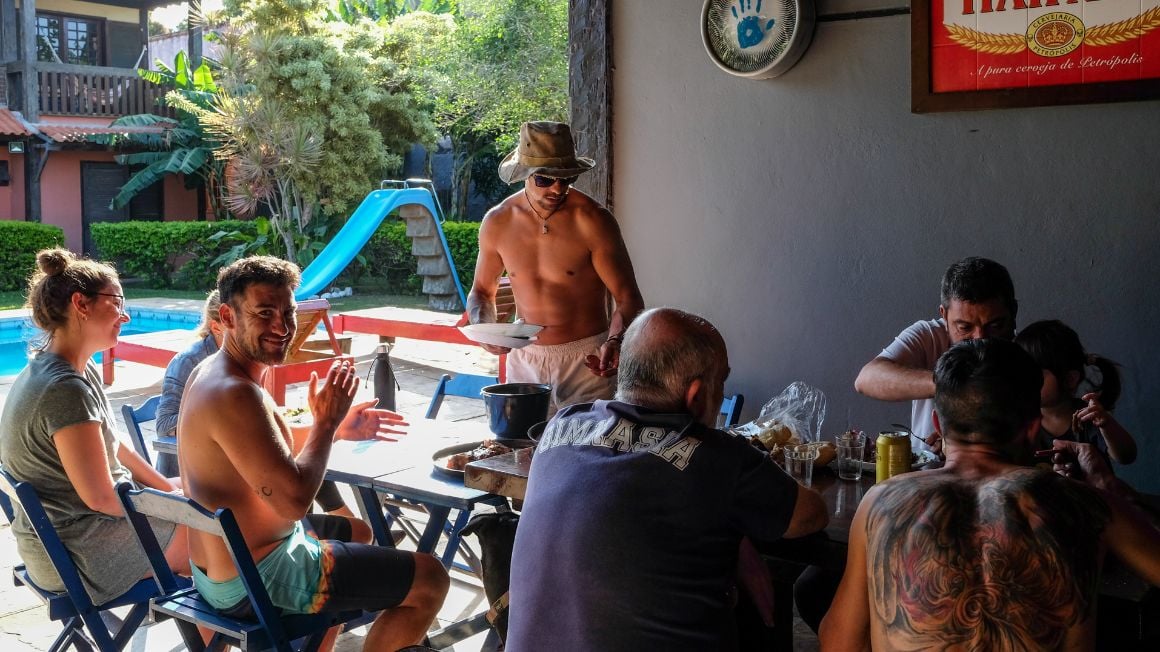 people sit together around a table in a hostel in brazil