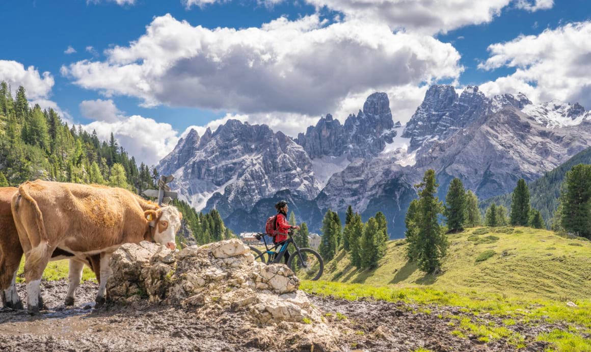 woman riding her mountain bike on the high plateau of Pratto Piazzo in the three peaks Dolomites Italy