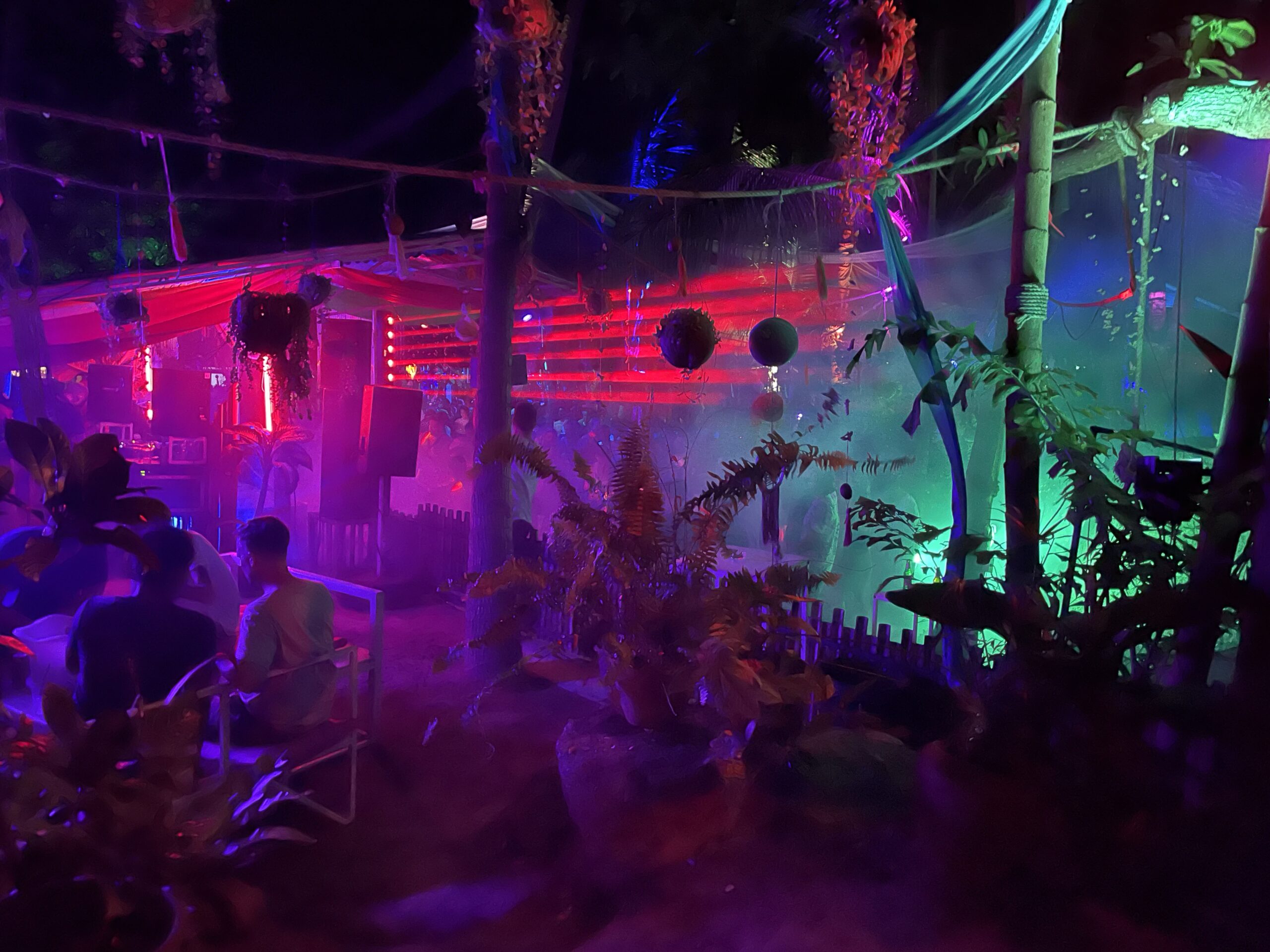 people partying among neon lights at haad rin on koh phangan