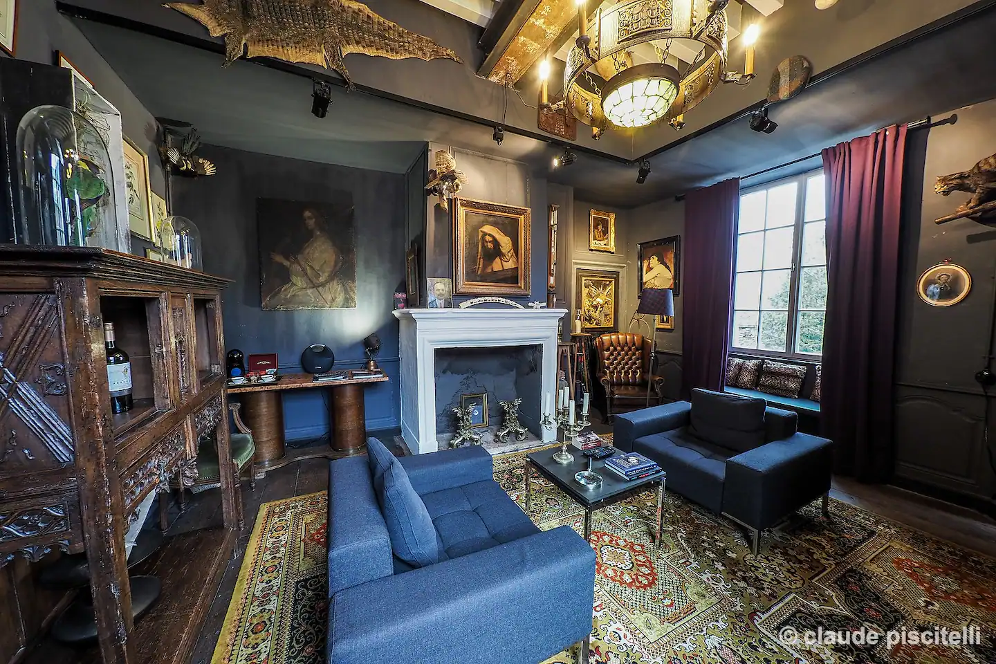 A sophisticated living room with antique décor and a charming fireplace.