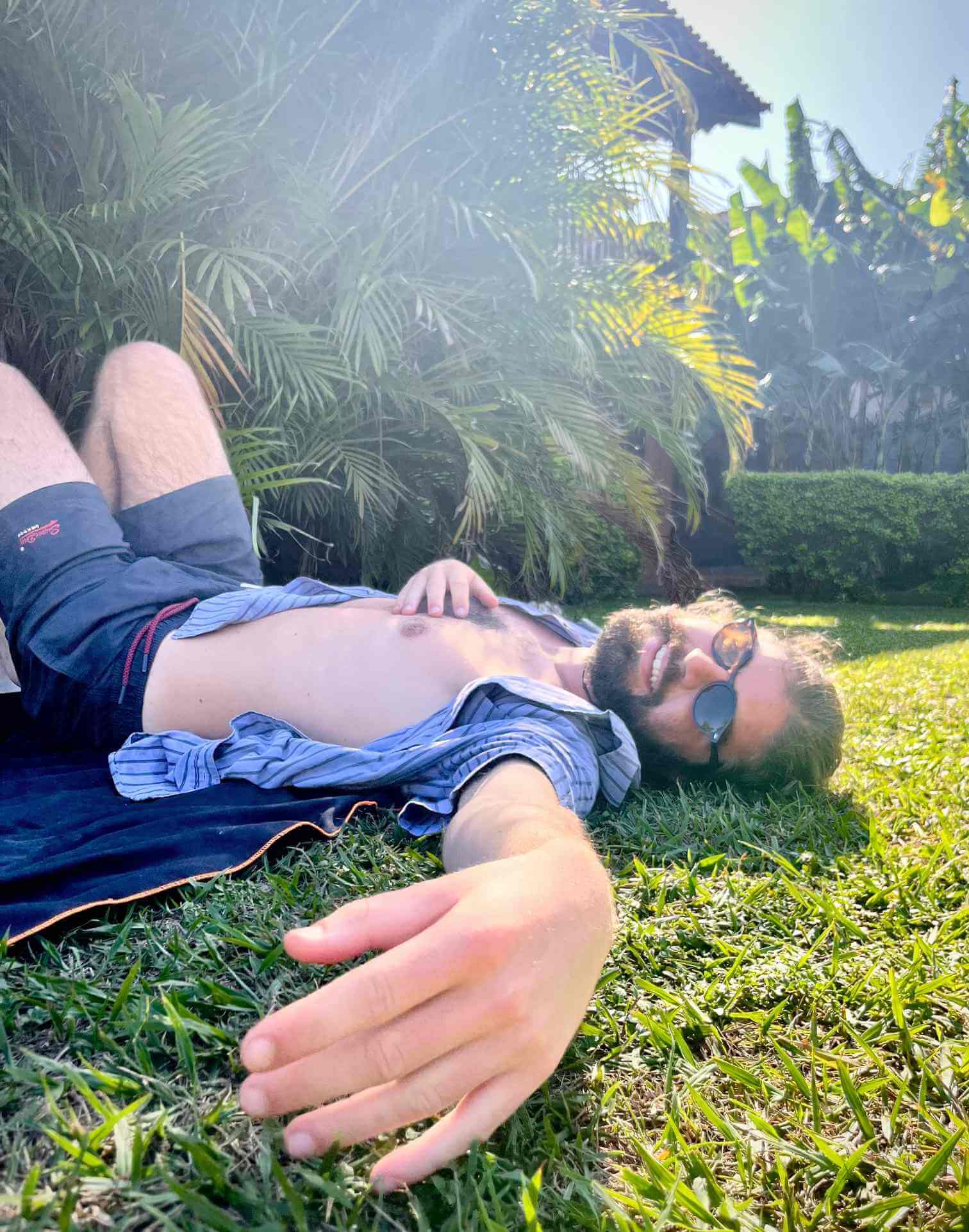 a hostel volunteer chills on the grass before his shift starts in buzios, brazil