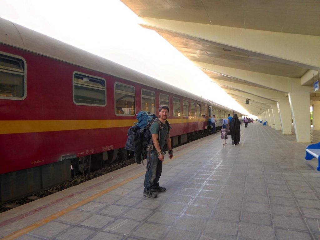 backpacker standing on a platform in a train station in iran
