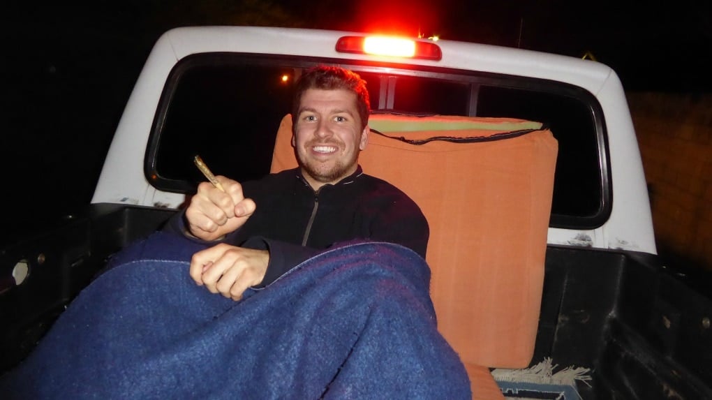 will hitchhiking through at night in the back of a pickup truck holding a joint