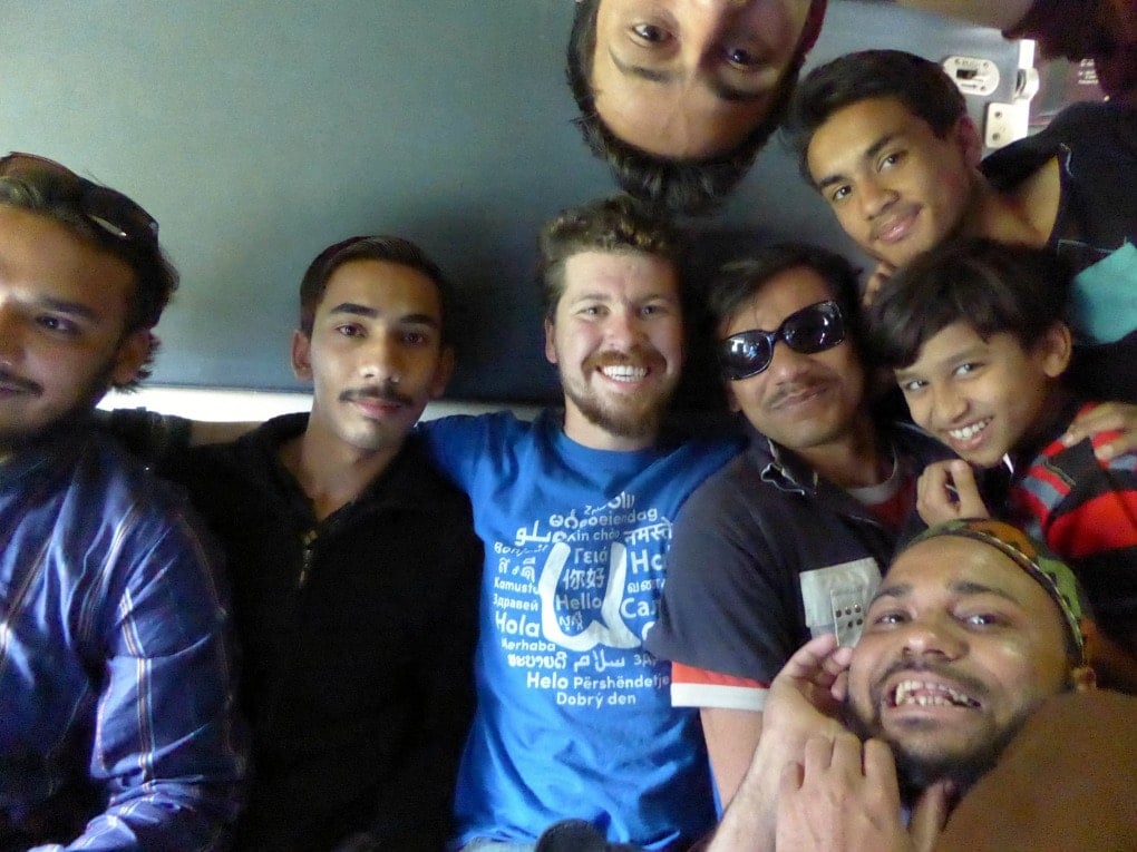 Will on a train travelling through Pakistan surrounded by locals