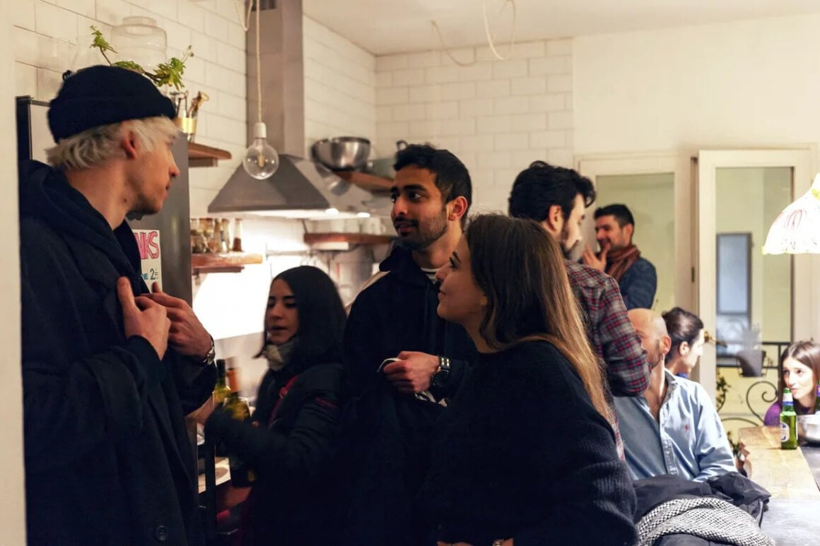 Friends chatting in the shared kitchen at Dopa Hostel