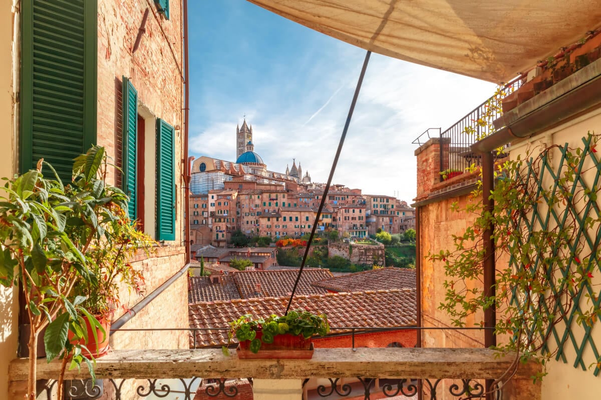 Siena city view between two historic buildings.