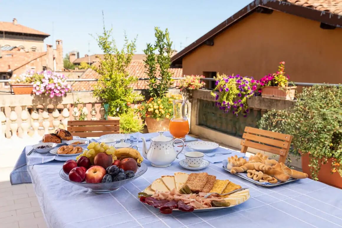 Table set for lunch at The Iride Suite on the rooftop terrace with terracotta roofs in the background.
