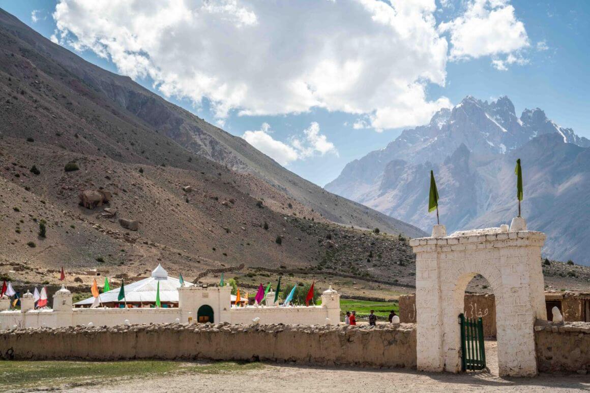 A gateway to a shrine is in a valley with massive mountains behind it