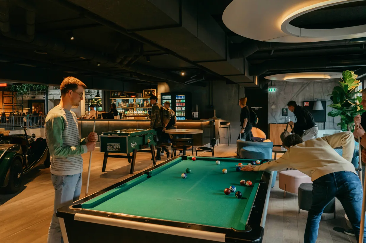 two guys playing pool at one of the best hostels in copenhagen
