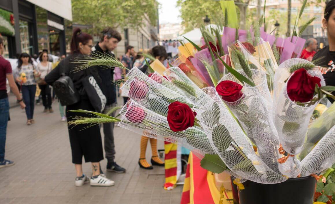 A bouquet of flowers with people strolling around Barcelona streets in the backdrop in Dia De Sant Jordi Barcelona