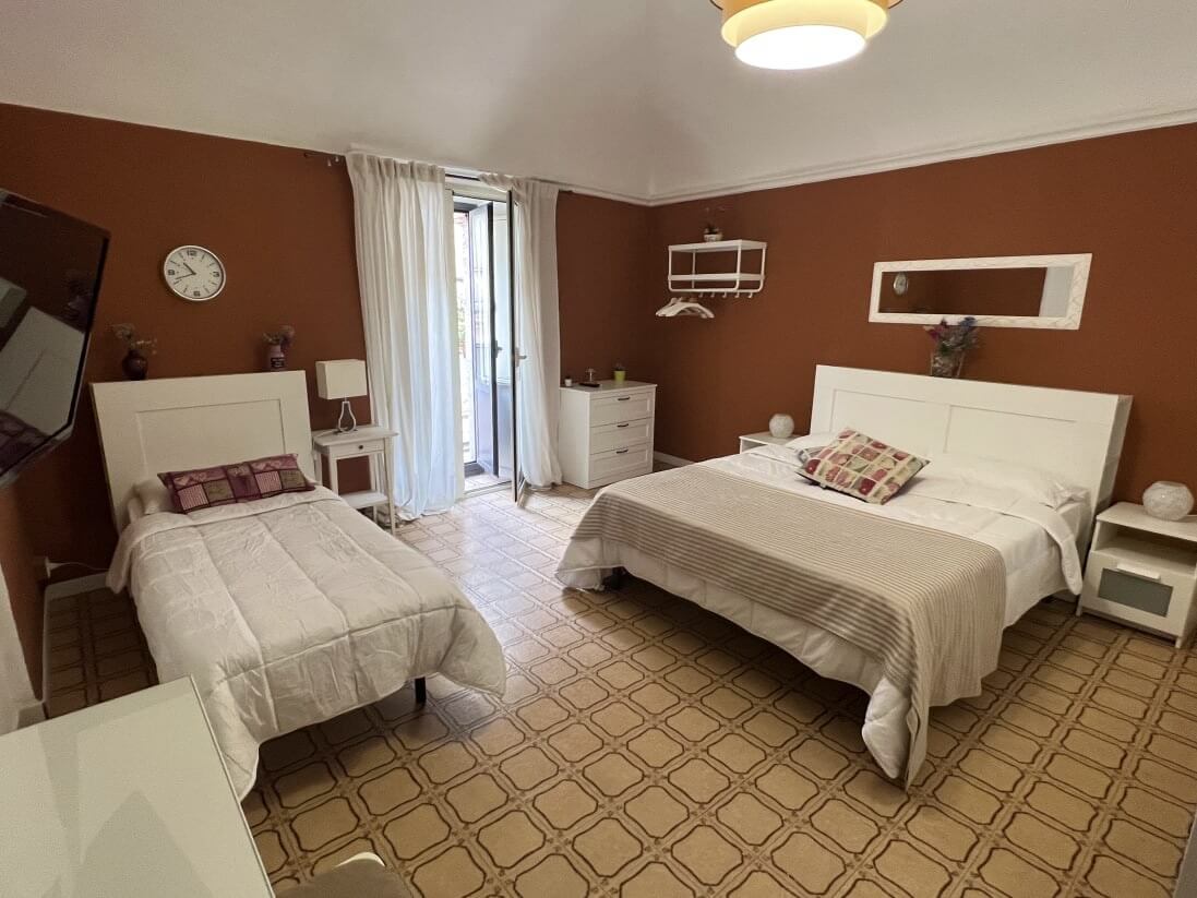 A triple room in B&B Doralice Catania fitted with a balcony.