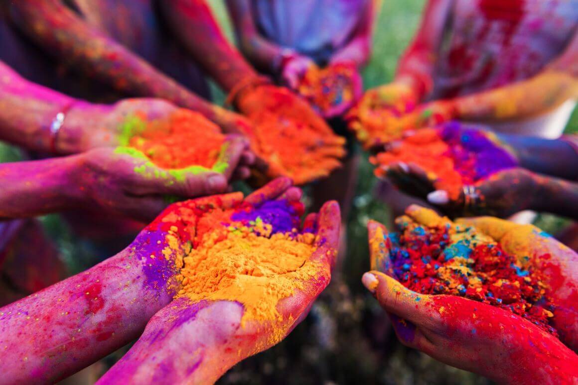 people holding colorful powders in their hands during Holi Festival Goa