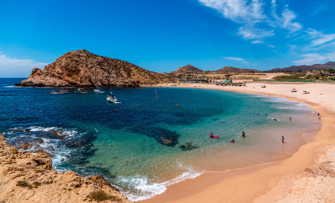Crystal-clear turquoise waters at Santa Maria beach Cabo San Lucas, with boats and rock formations.