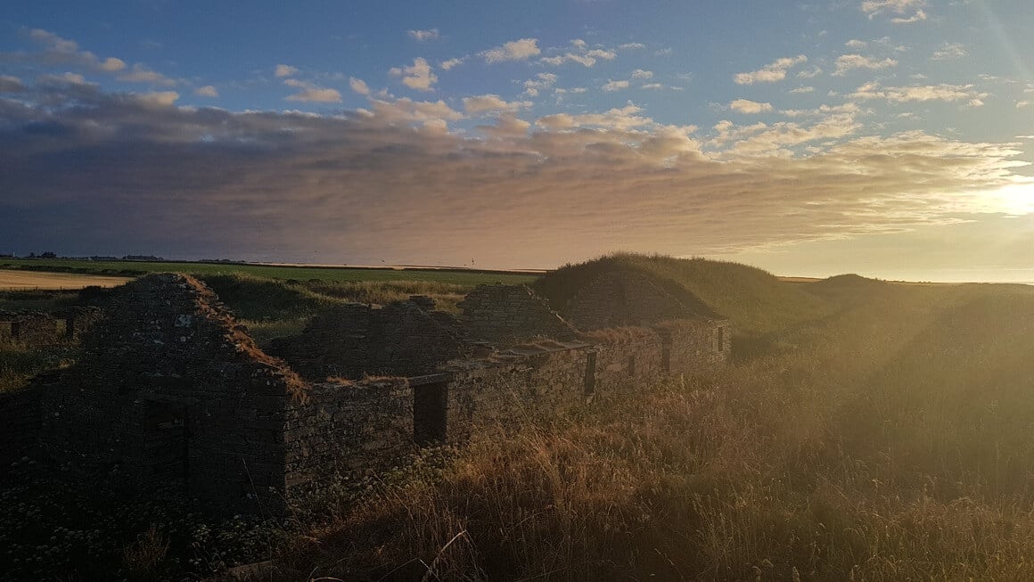 The sunsetting over some ruins in the British countryside 