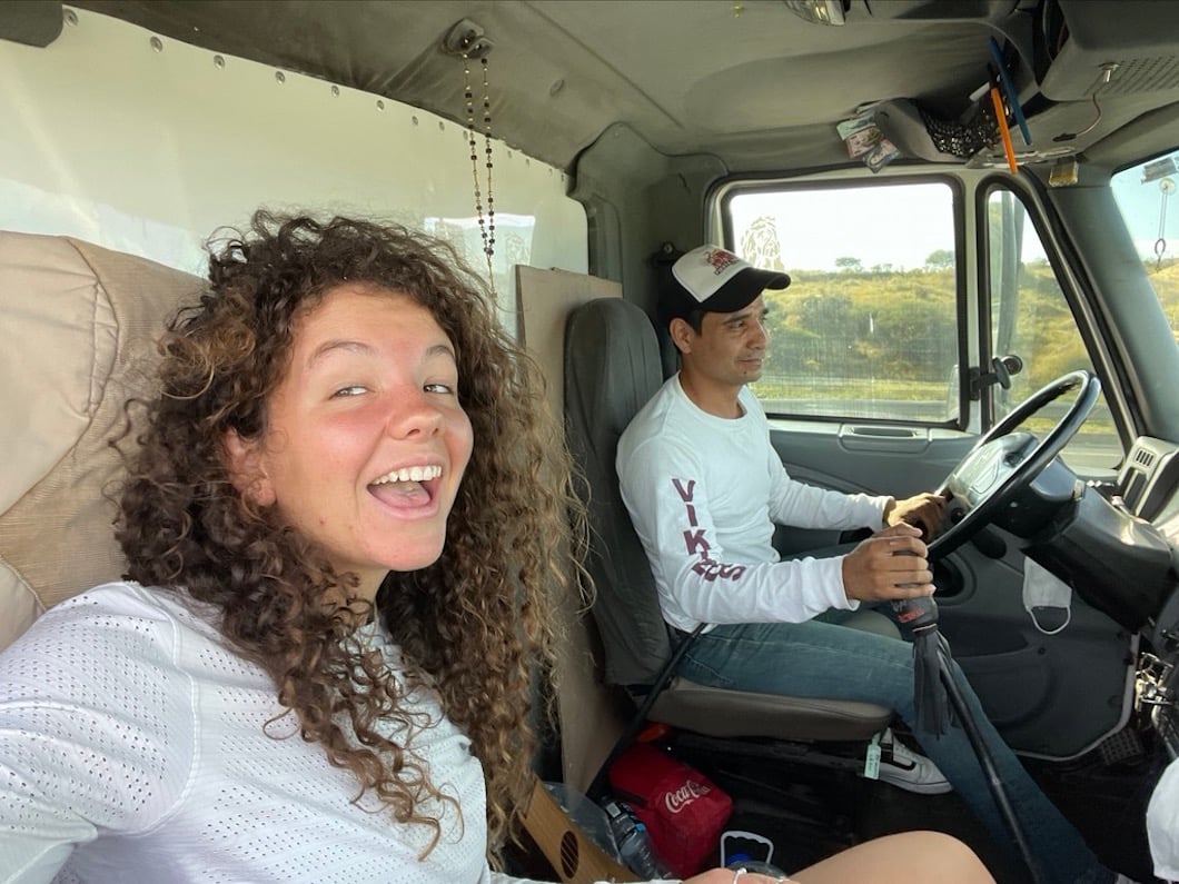 Girl takes selfie with pickup truck driver while hitchhiking in Mexico.