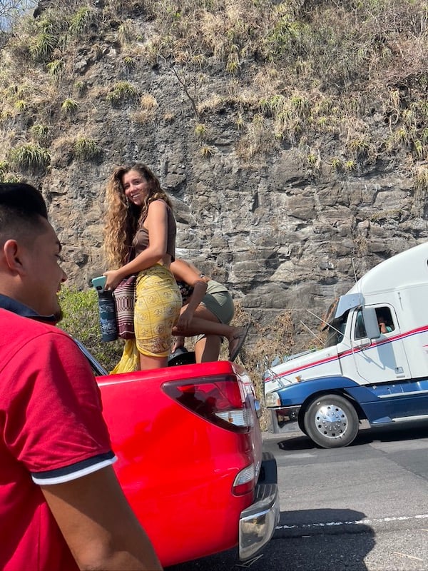 Two girls hopping into a truck in EL Salvador whilst hitchhiking. 