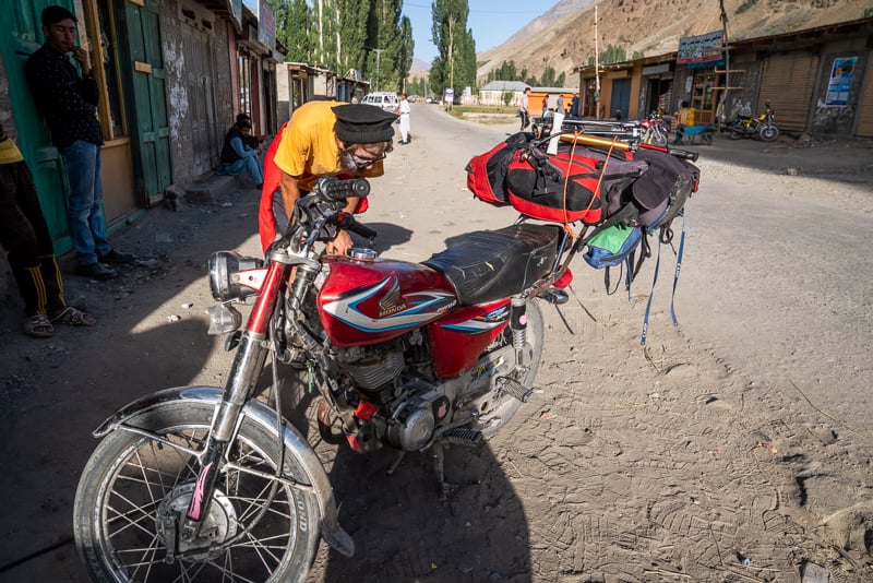 guy inspecting a motorbike in pakistan