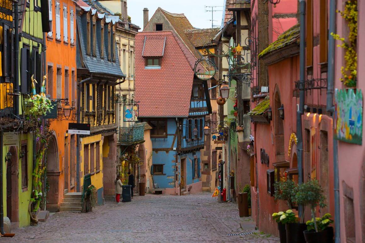 A narrow street lined with colorful houses in Riquewihr town, France