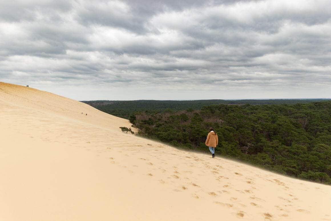 A girl waling through the Dune de Pilat in France