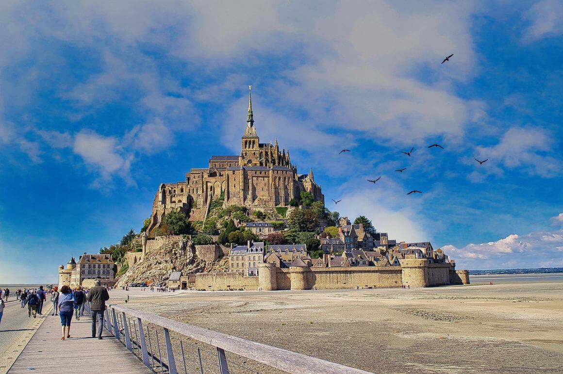 A group of people walking across Mont Saint-Michel, in France