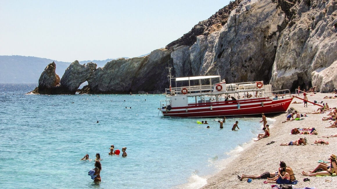 People enjoying a day of swimming and sunbathing in Lalaria Beach Skiathos