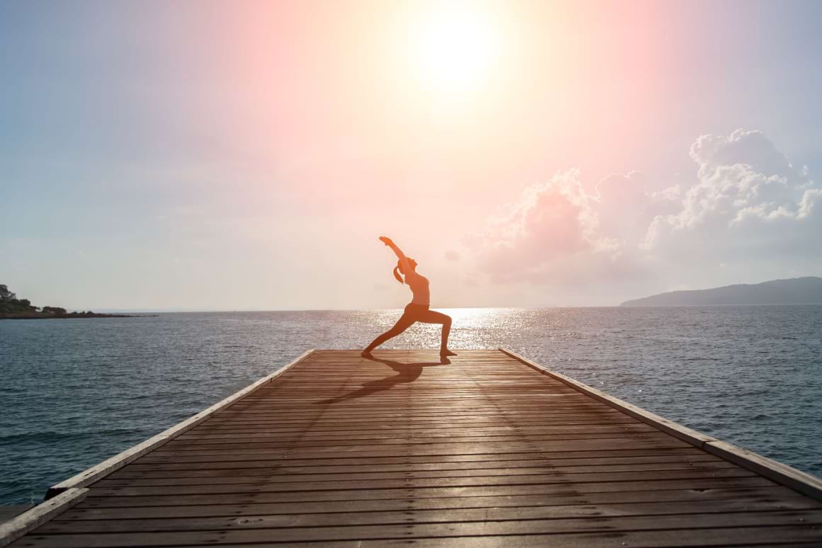 Yoga warrior pose at sunset