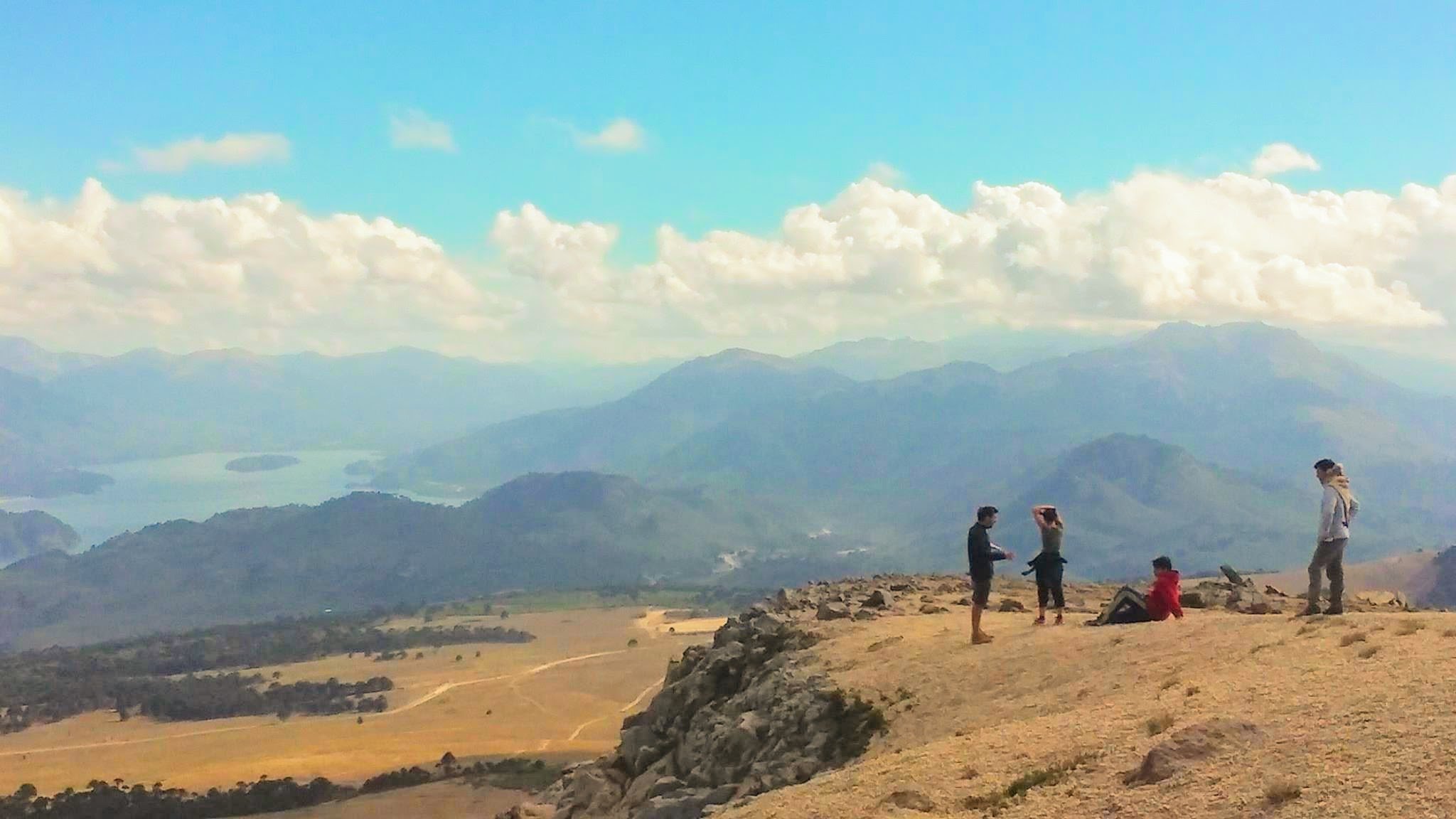 Group of travellers looking the view of mountains and lakes in Neuquen, Argentina.