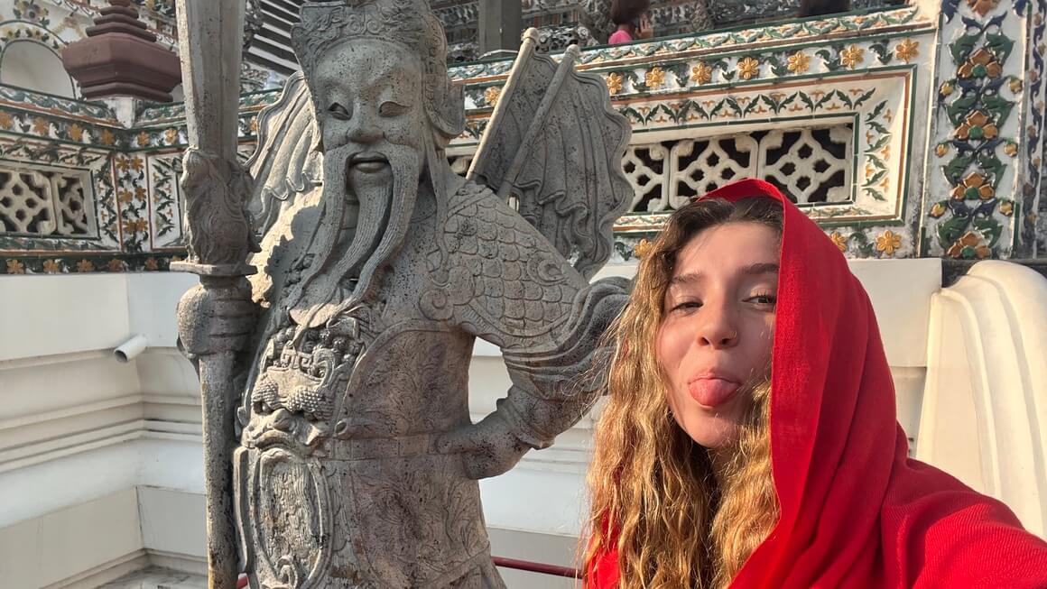 Woman standing next to a Chinese warrior statue in Bangkok, Thailand