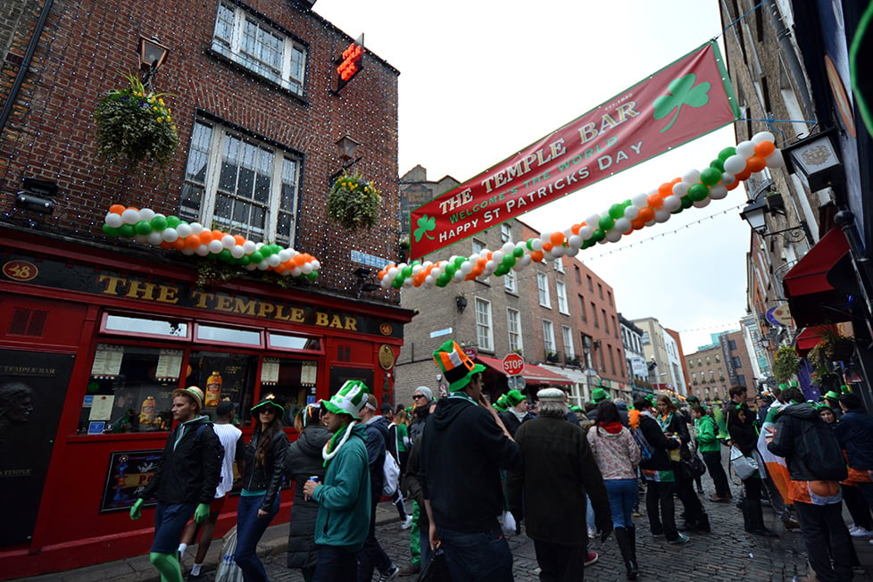 people walking around Temple Bar in fancy dress on St Patrick's Day in Dublin.