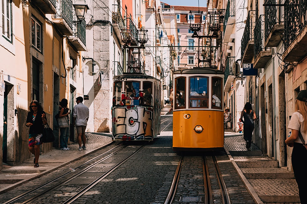 trams crossing paths on a steep street in Lisbon, Portugal