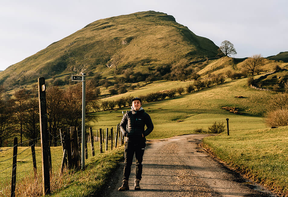 A person standing in front of a peak after a hike in the UK