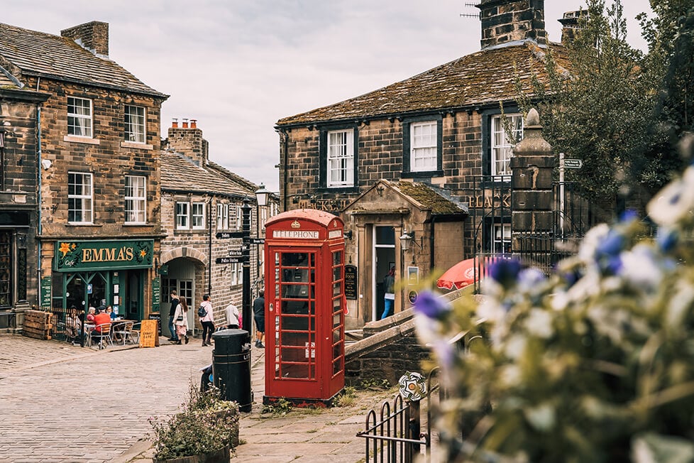 A red phone box on a quaint street in an English village