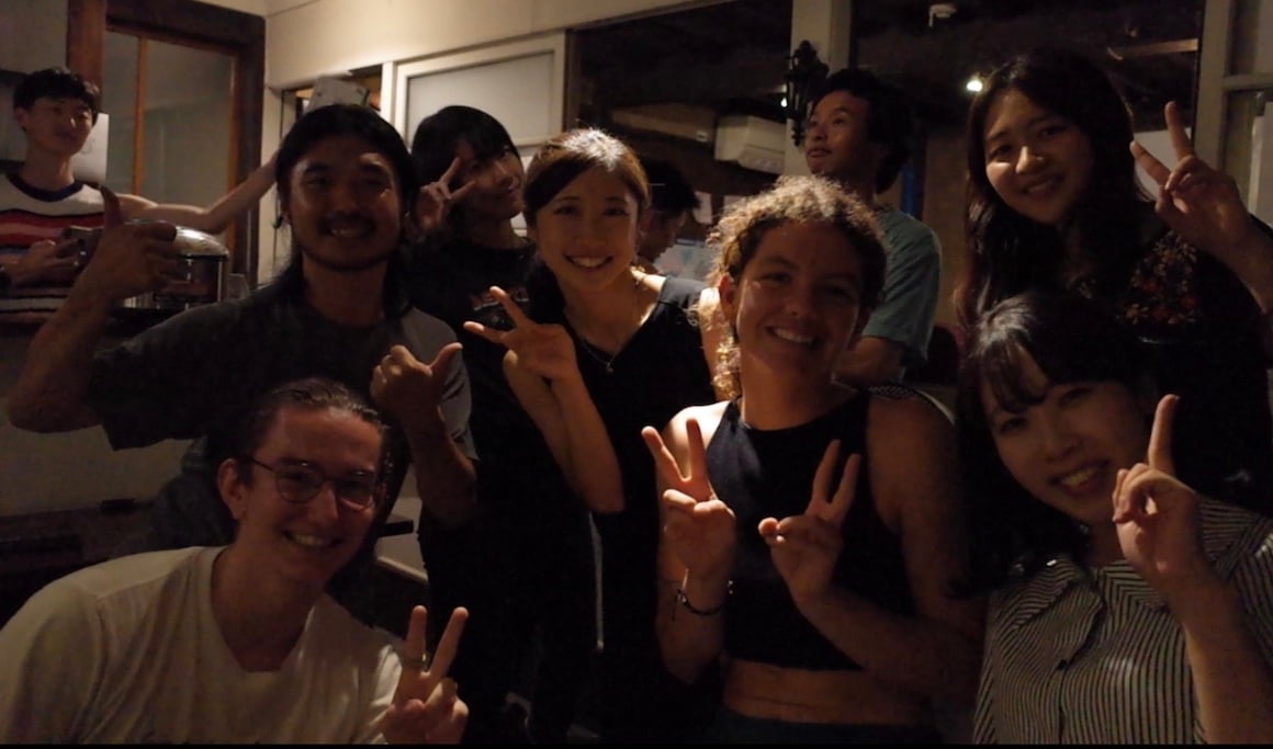 A group of friends smiles for a picture while in a hostel in Nagano, Japan.