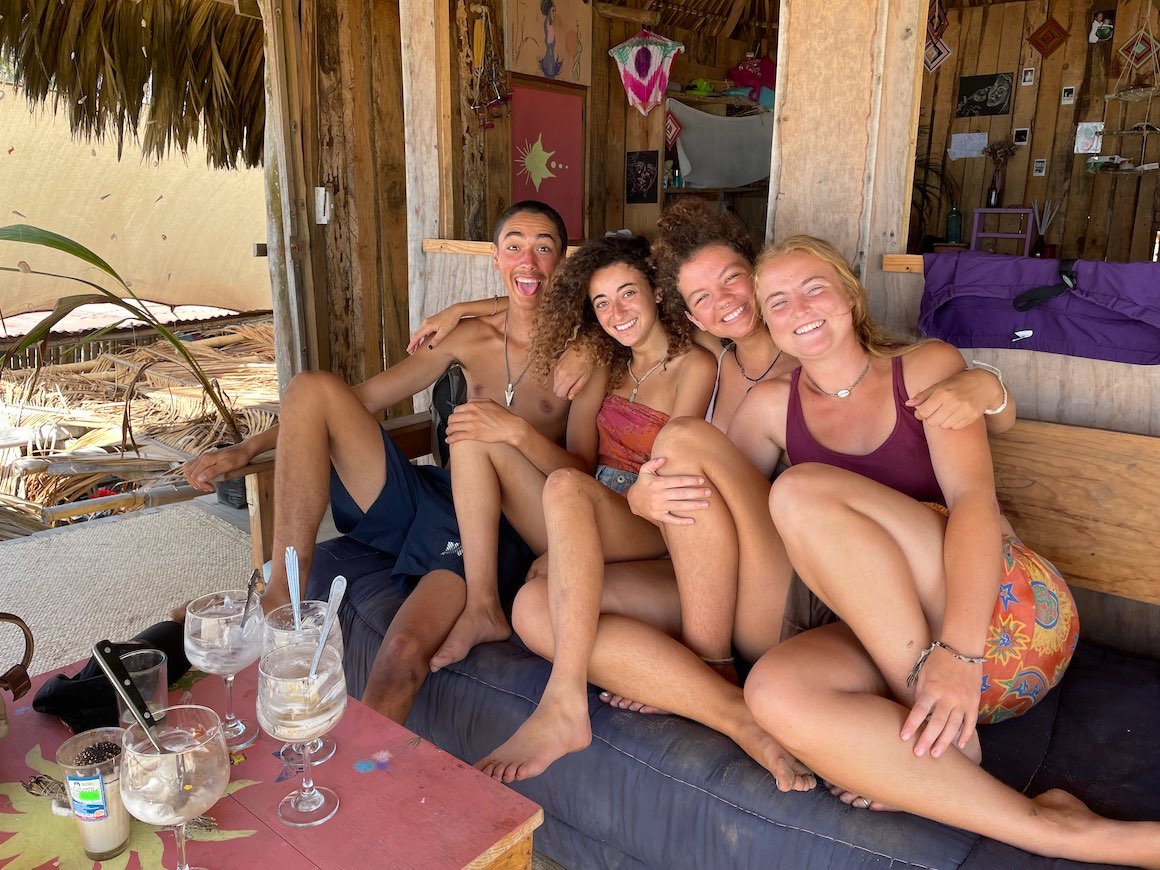 A group of friends smiles fro a photo as they sit in a casita in Oaxaca, Mexico.