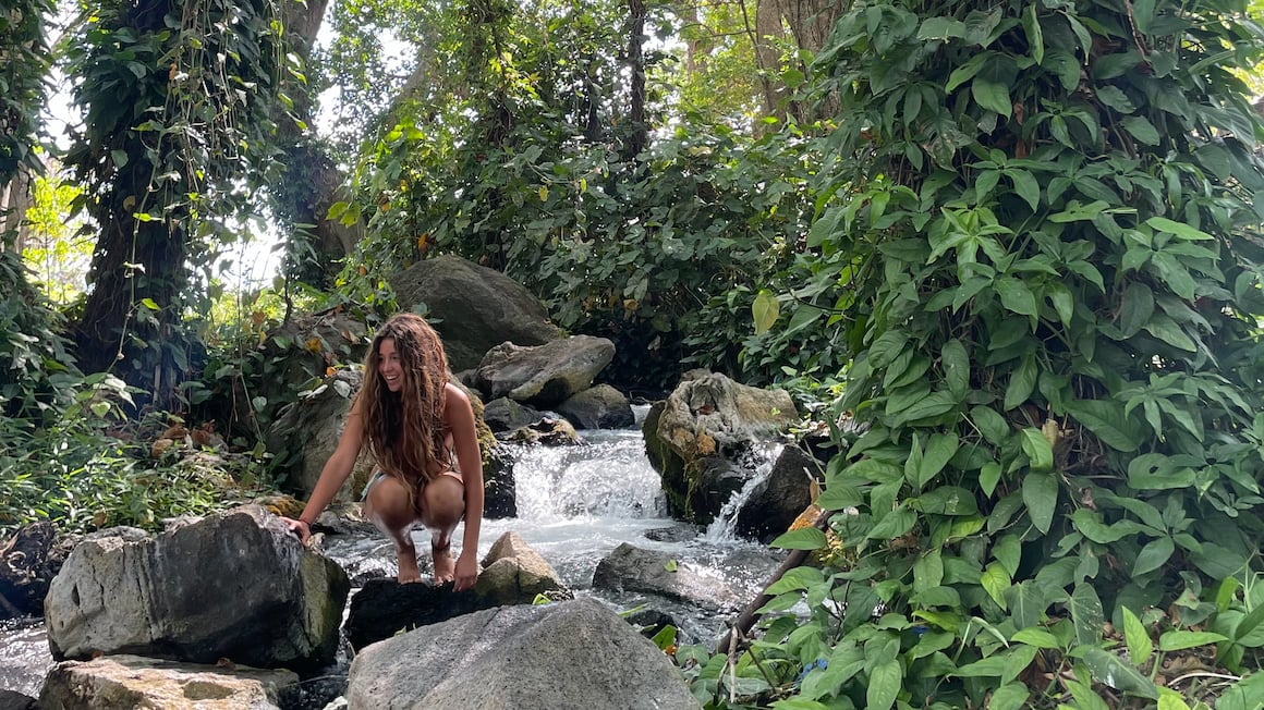 girl sitting by a stream in the jungle of Ometepe, Nicaragua  