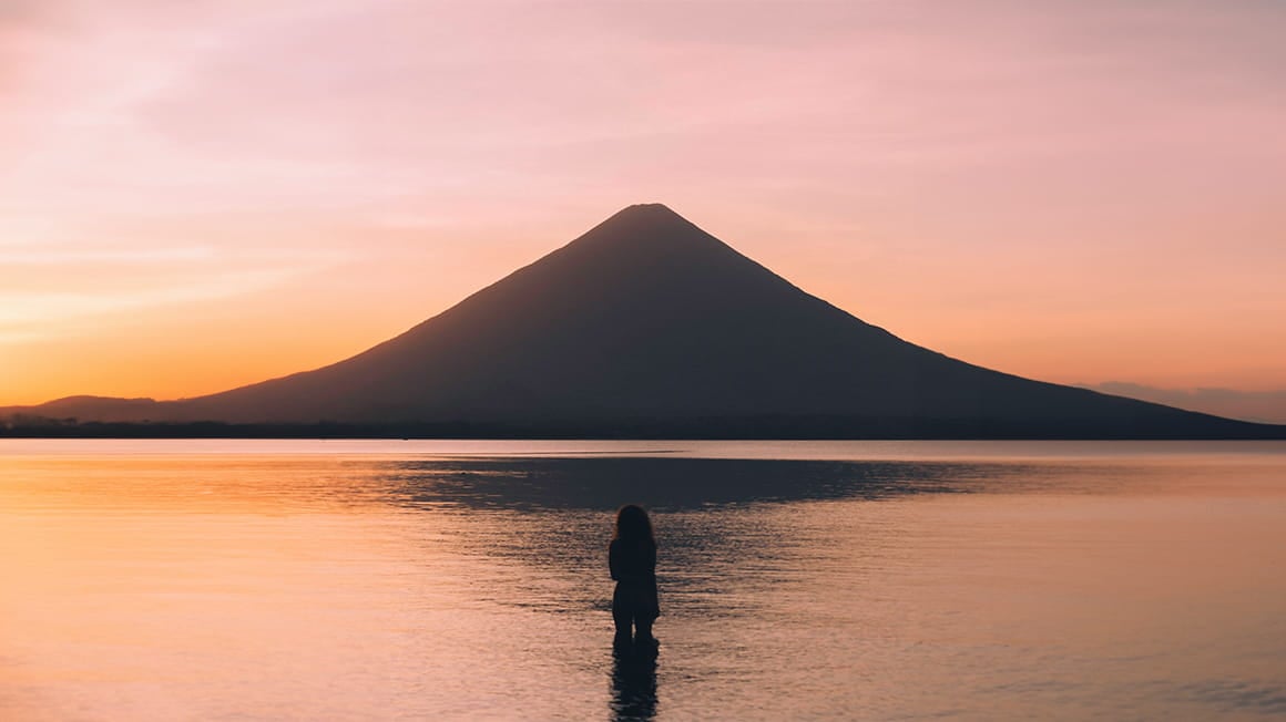 girl in lake watching the sunset