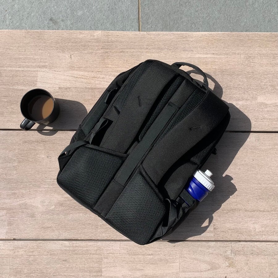 The back of the tomtoc orange laptop backpack with a coffee