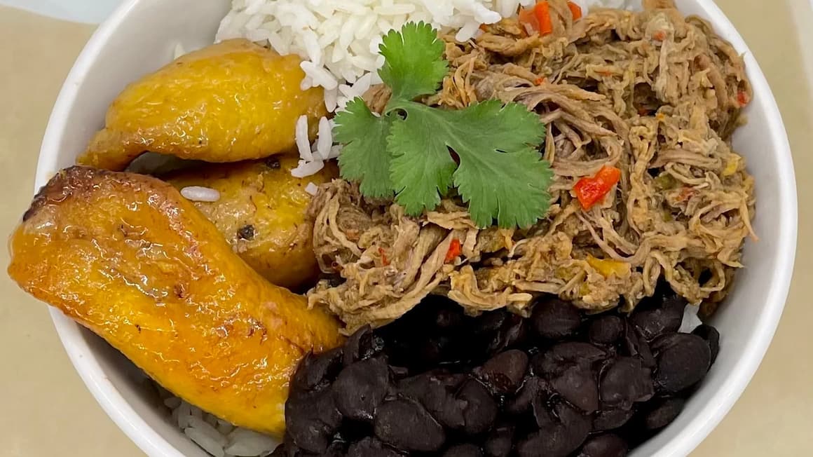 the national dish in venezuela, served with rice, beans, plantains, and shreaded chicken 