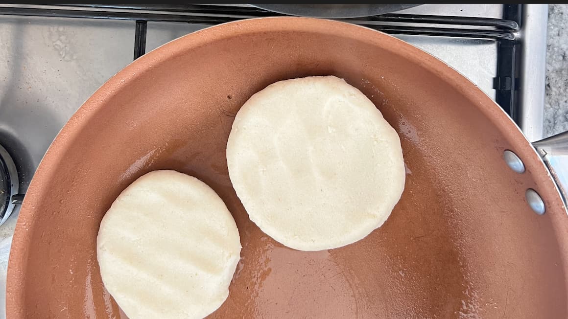 cooking arepas, a venezuelan dish